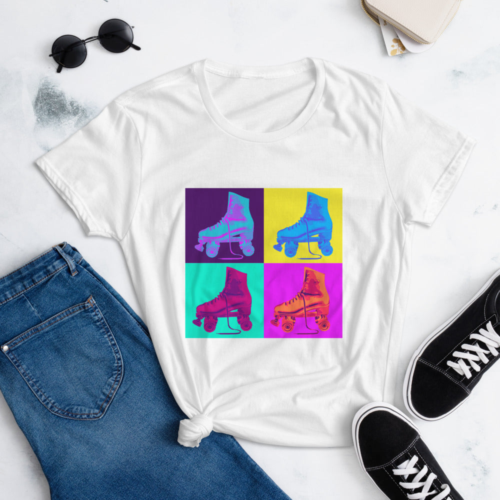 A flat photo of a white roller skate Tshirt, knotted at the side, with a print 4 brightly colored roller skates on bright coloured background squares.  The print is in a silk screen style.